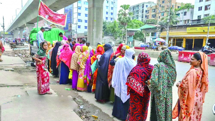 People wait in queues to buy daily necessities