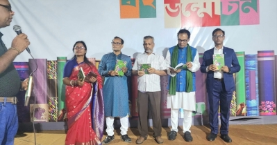 Journalist Deepak Acharjee opens book cover of novel, “Sesh Mohonay” at Ekushe Book Fair