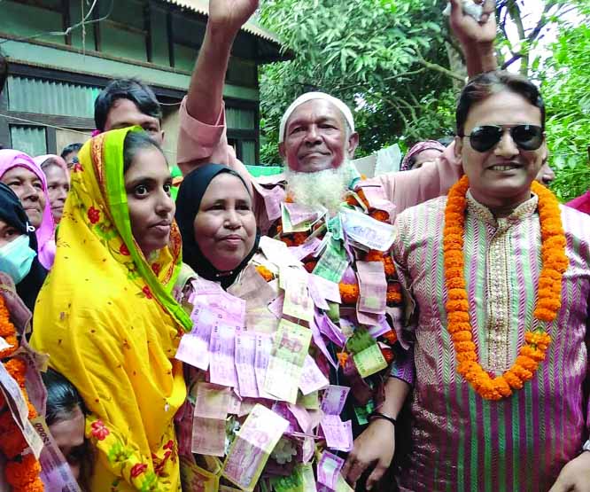 Reserved female member of Titas greeted with a garland of lakhs of Taka